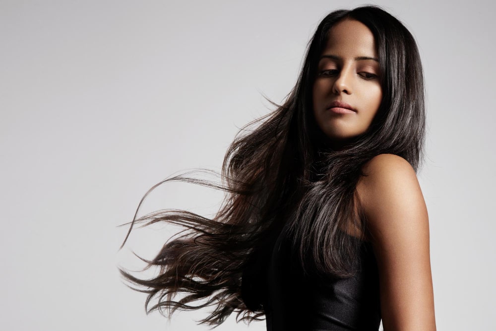 “Straight tape-in hair extensions made from 100% real human hair in natural black”
